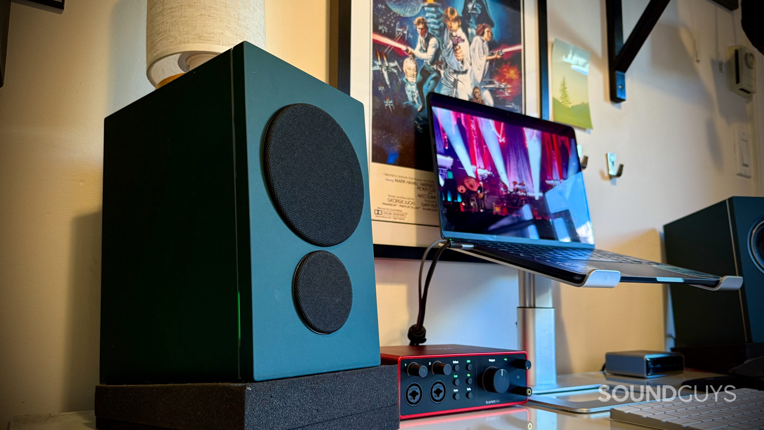 PSB iQ2 powered speaker with grille installed beside a laptop and Focusrite Scarlett 4i4