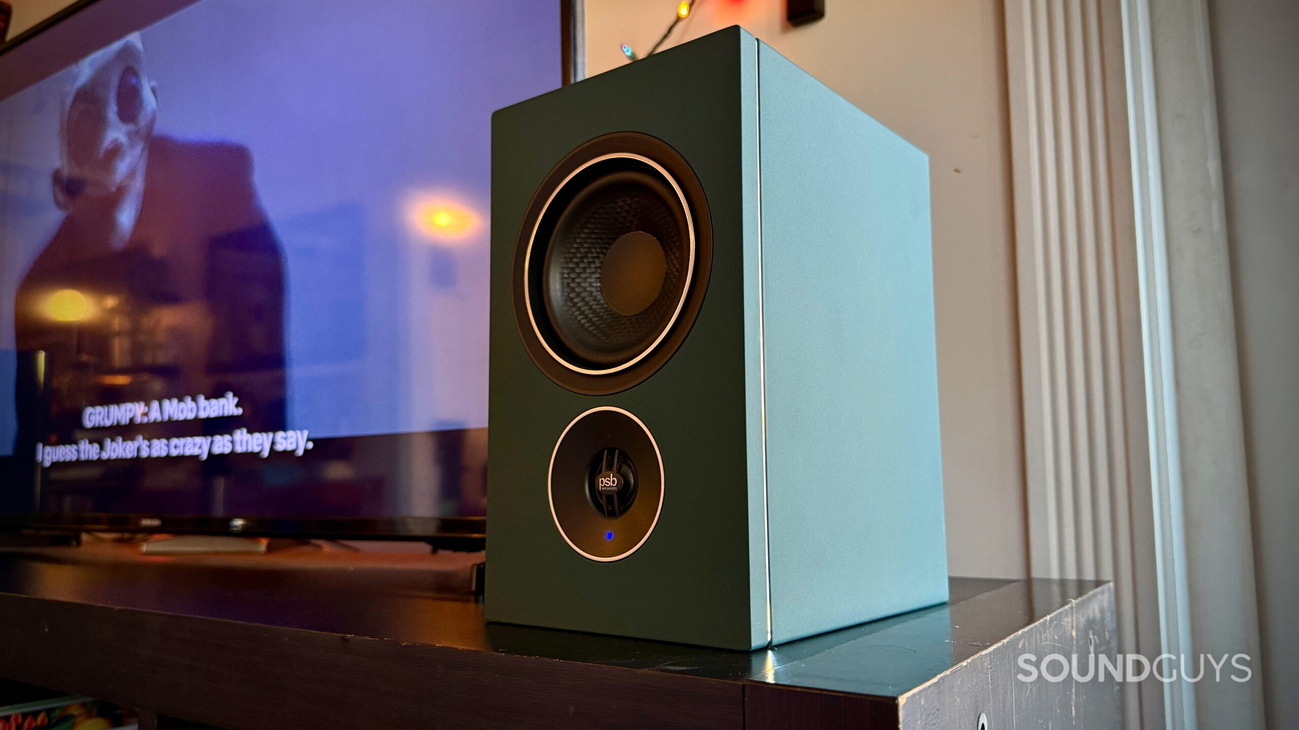 psb iQ2 speakers - 8 PSB iQ2 powered speaker in Boreal Green with its grille removed beside a TV
