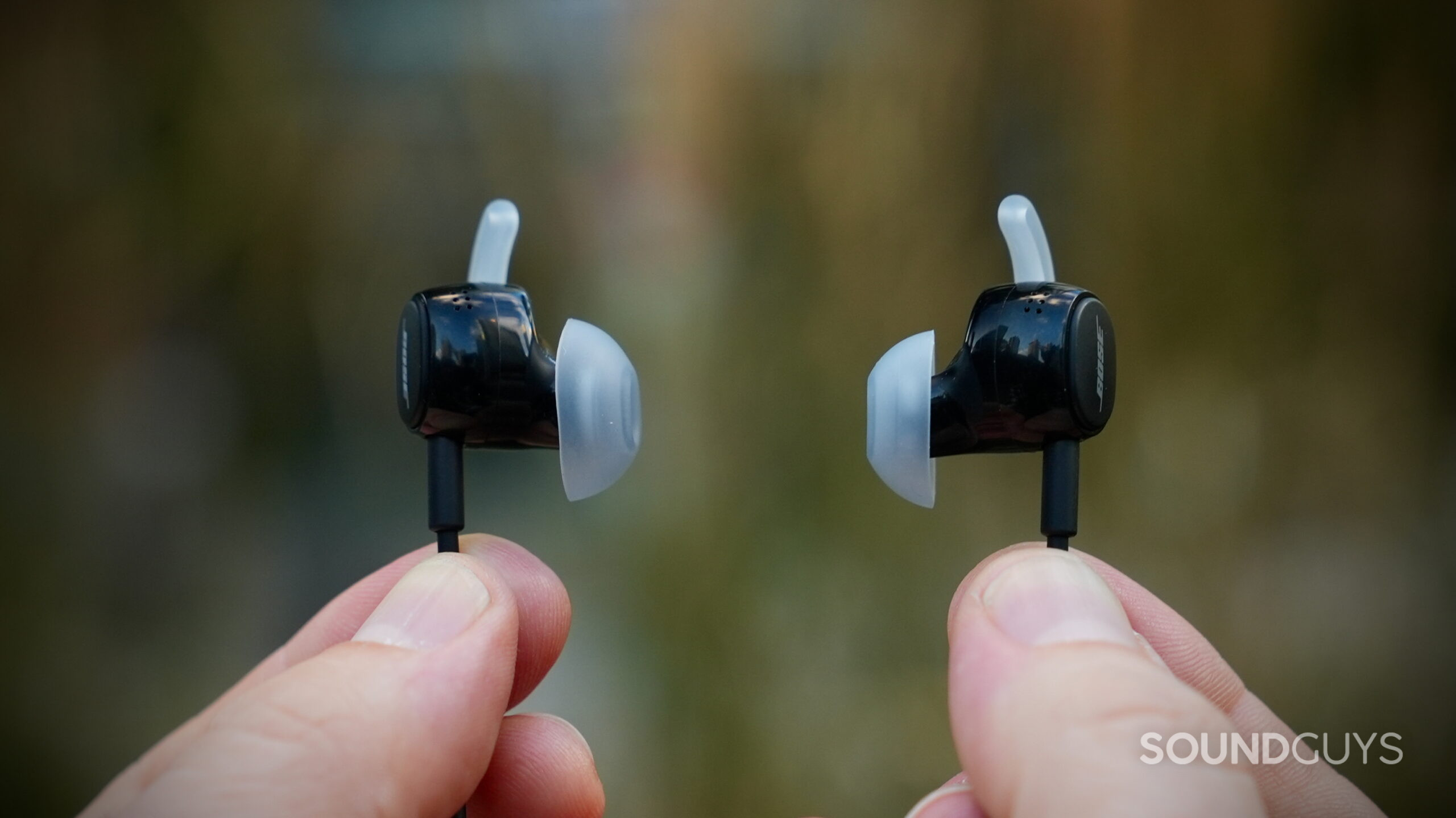 Close-up of two Bose earbuds showing their silicone tips and stabilizer wings.