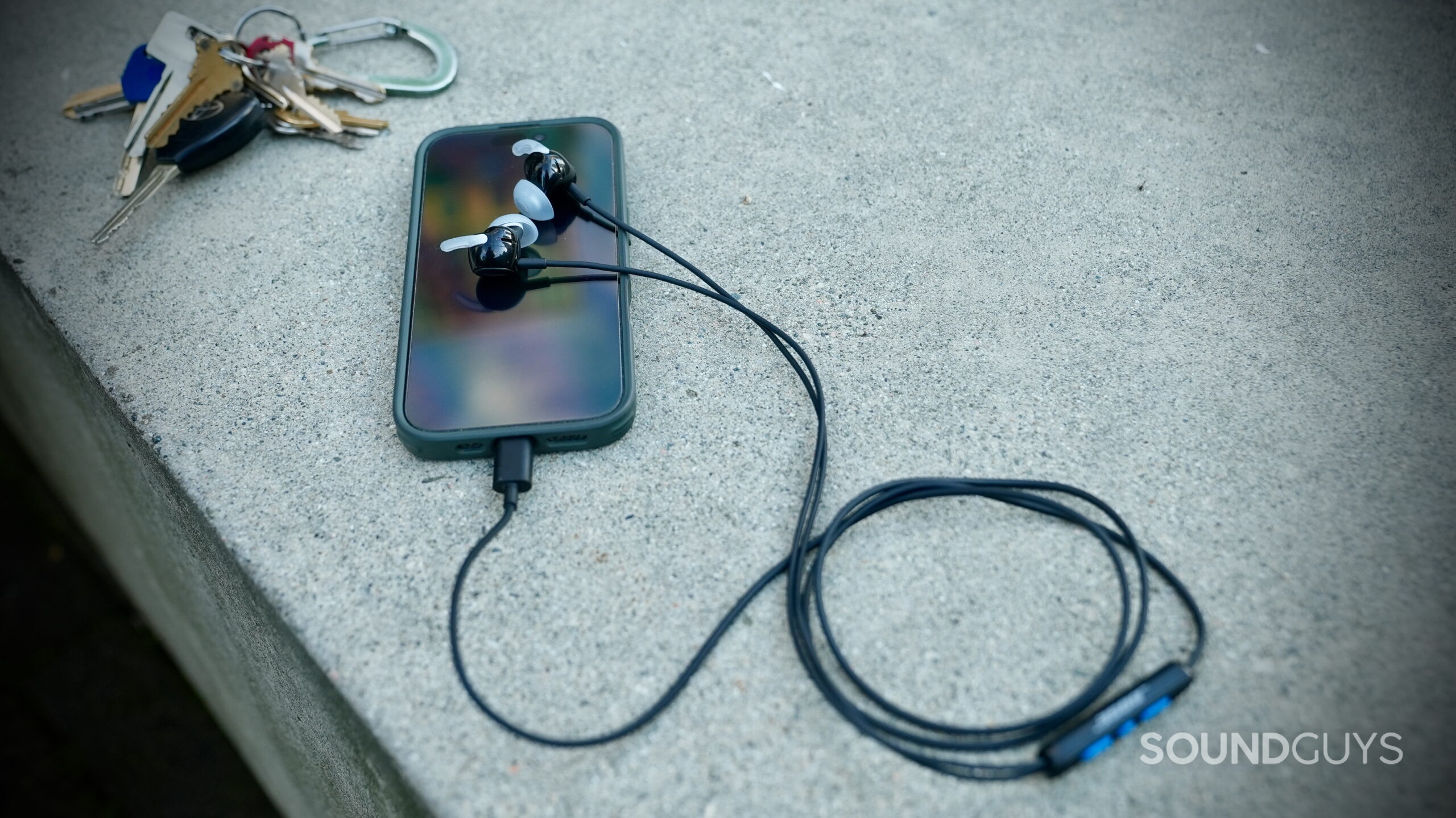 Bose Noise Canceling Wired Earbuds - 7 Bose USB-C earbuds connected to a smartphone, with the inline remote visible.