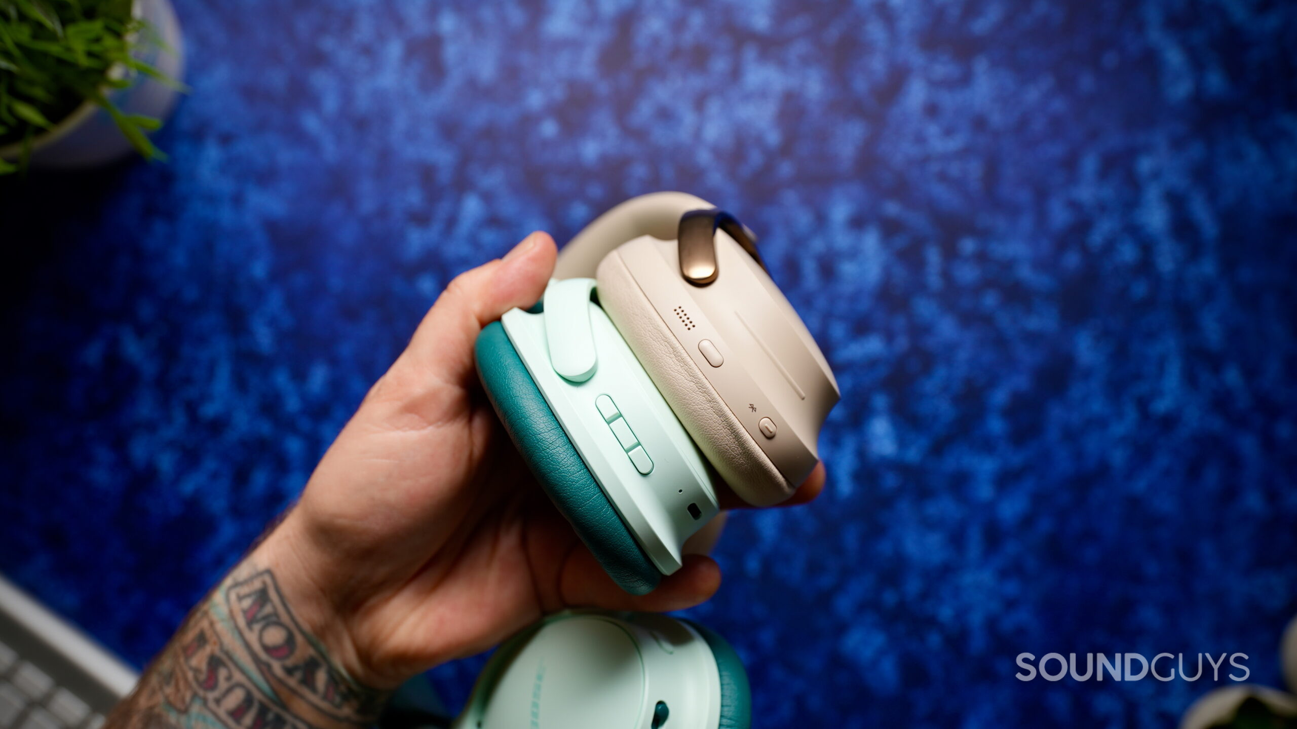 Side view of the Bose QuietComfort Headphones (2nd Gen) and QuietComfort Ultra Headphones (2nd Gen), showing their different button layouts.