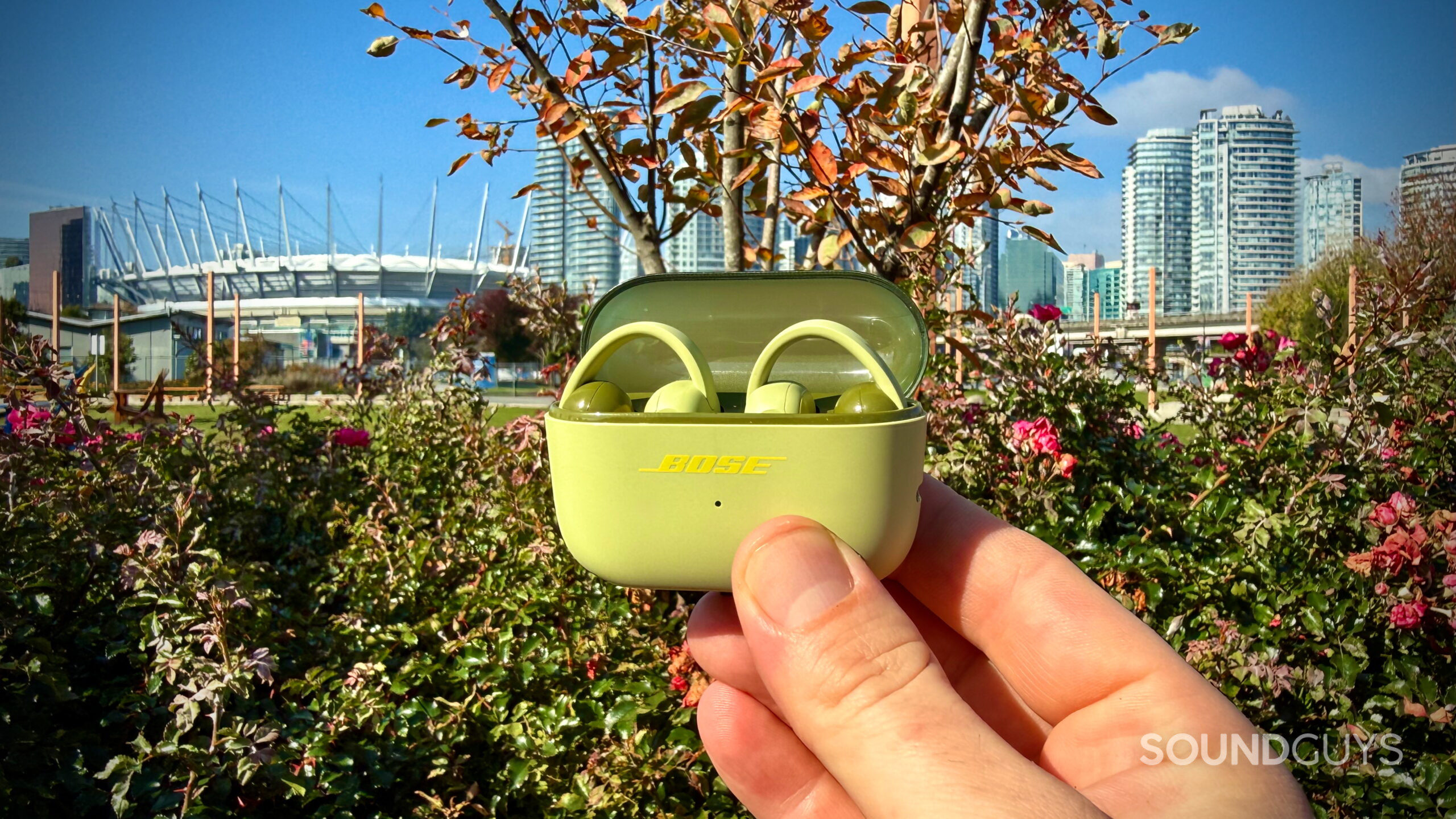 Bose Sport Open Earbuds - 1 (1) Bose Sport Open Earbuds in their open charging case outdoors