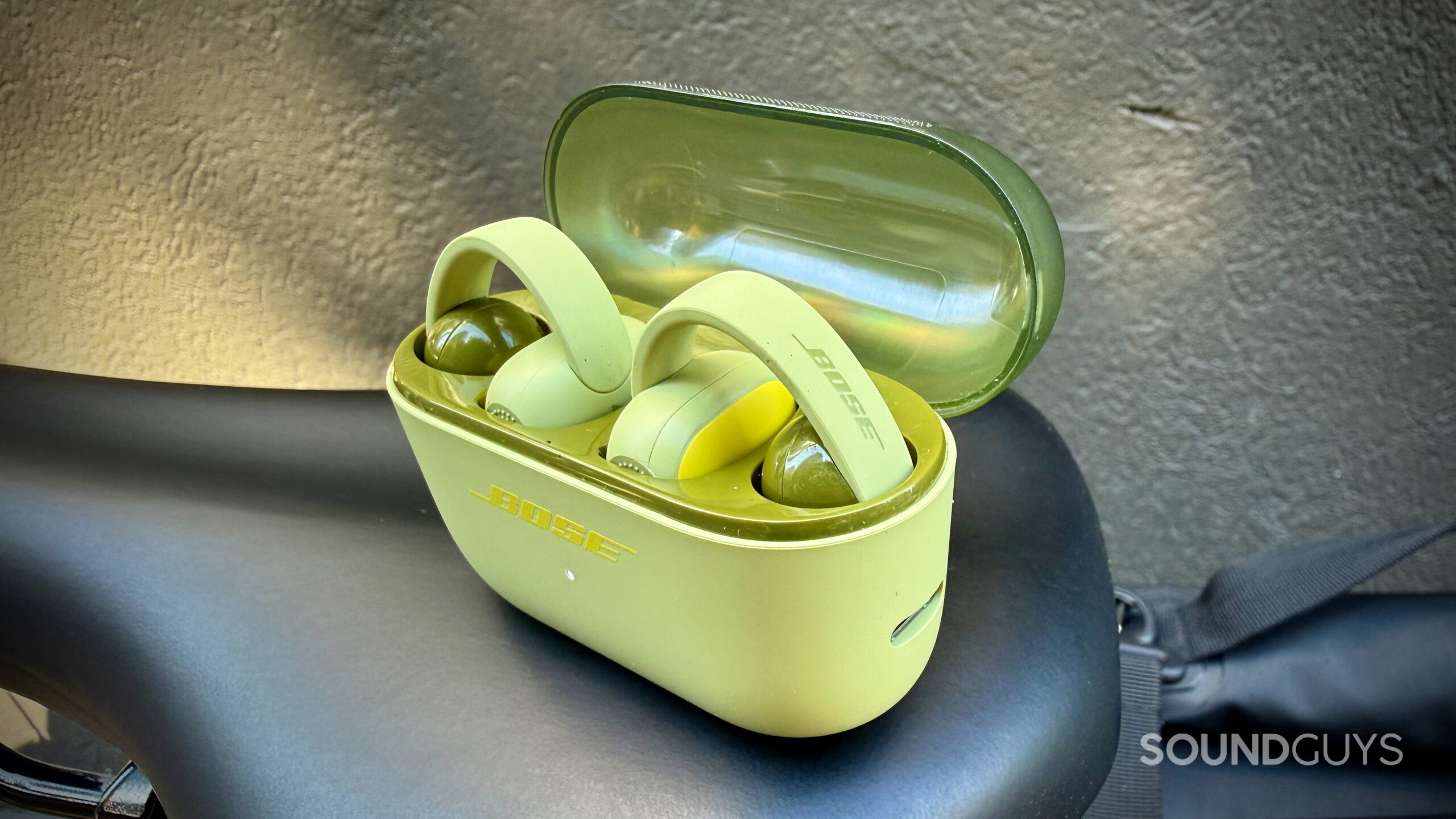 Bose Sport Open Earbuds - 4 Bose Sport Open Earbuds inside their open charging case