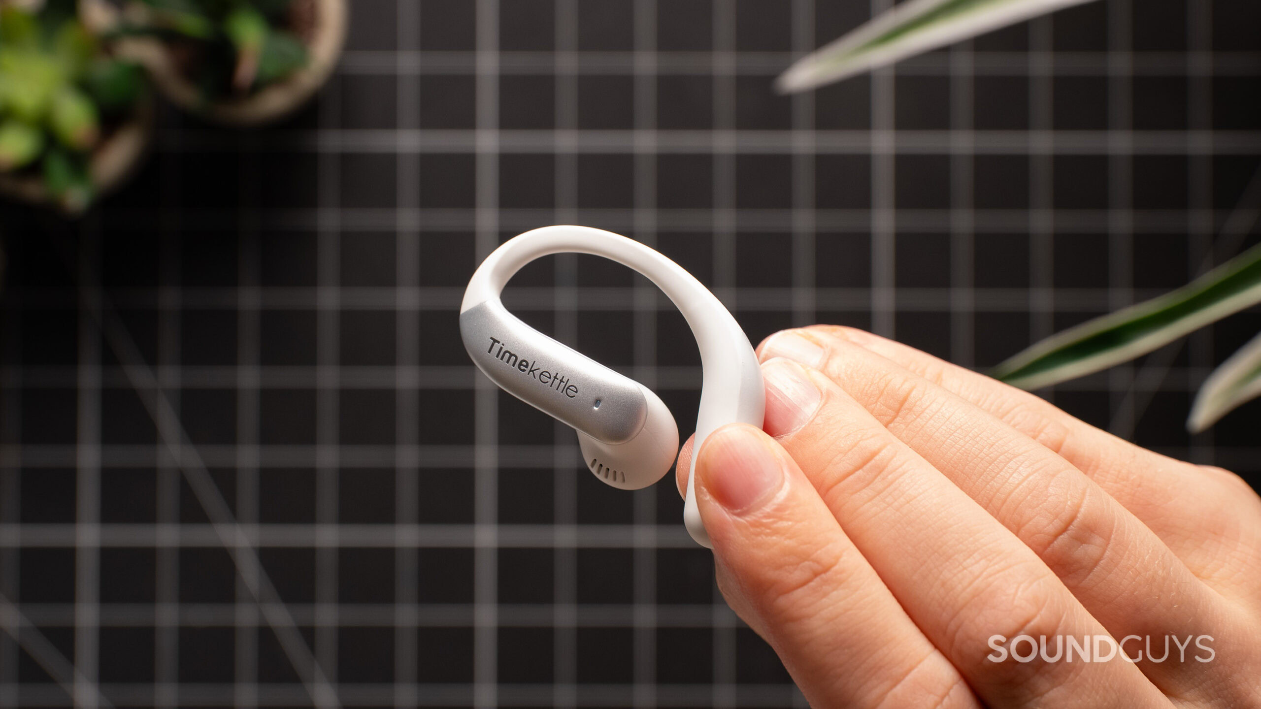 Timekettle Livetalk earbud held in hand.